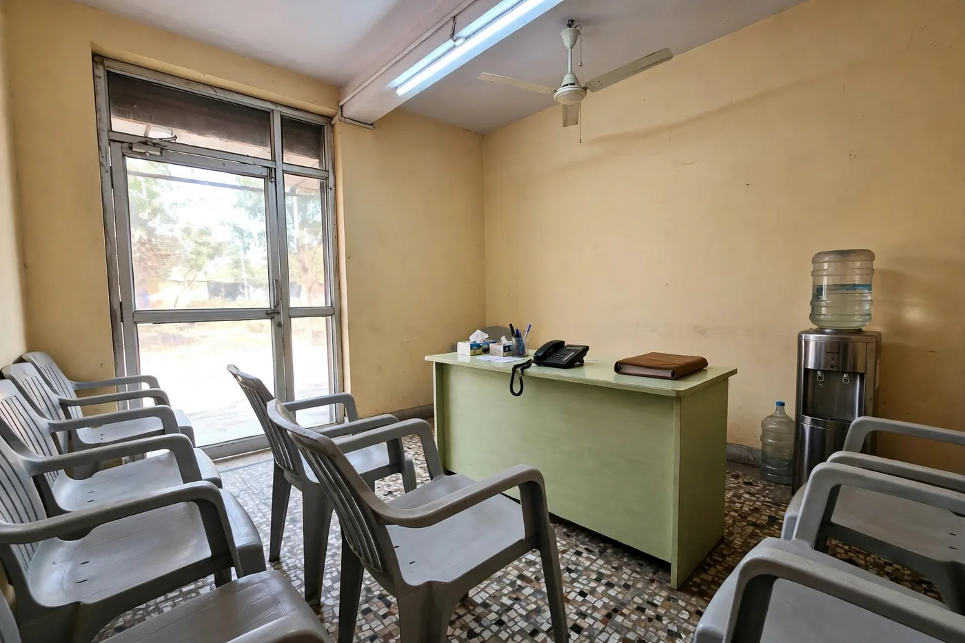 The waiting room at Dentistree — plastic chairs, the front desk and daylight through the glass doors